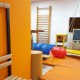 Salle de rééducation avec ballon, espaliers et balançoire pour séances de renforcement et prévention des incapacités